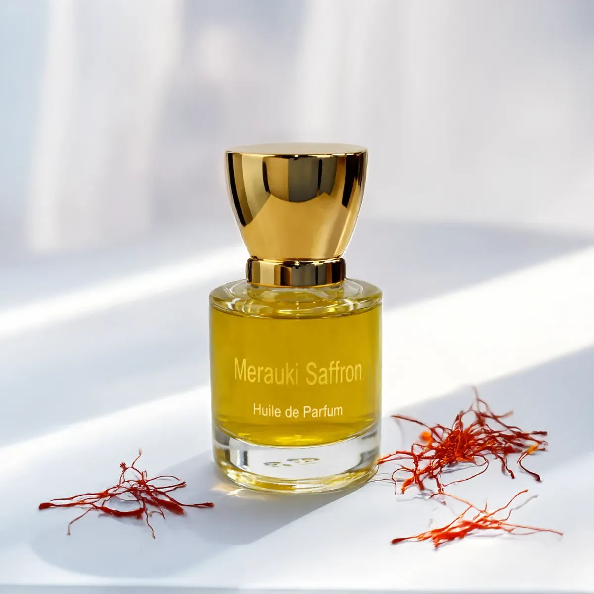 Merauki Saffron huile de parfum surrounded by vibrant saffron strands in soft natural light