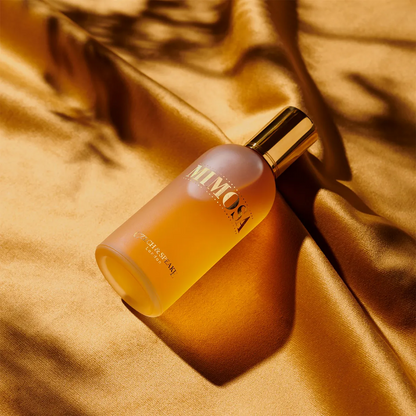 Yellow bottle with gold cap on a textured brown surface