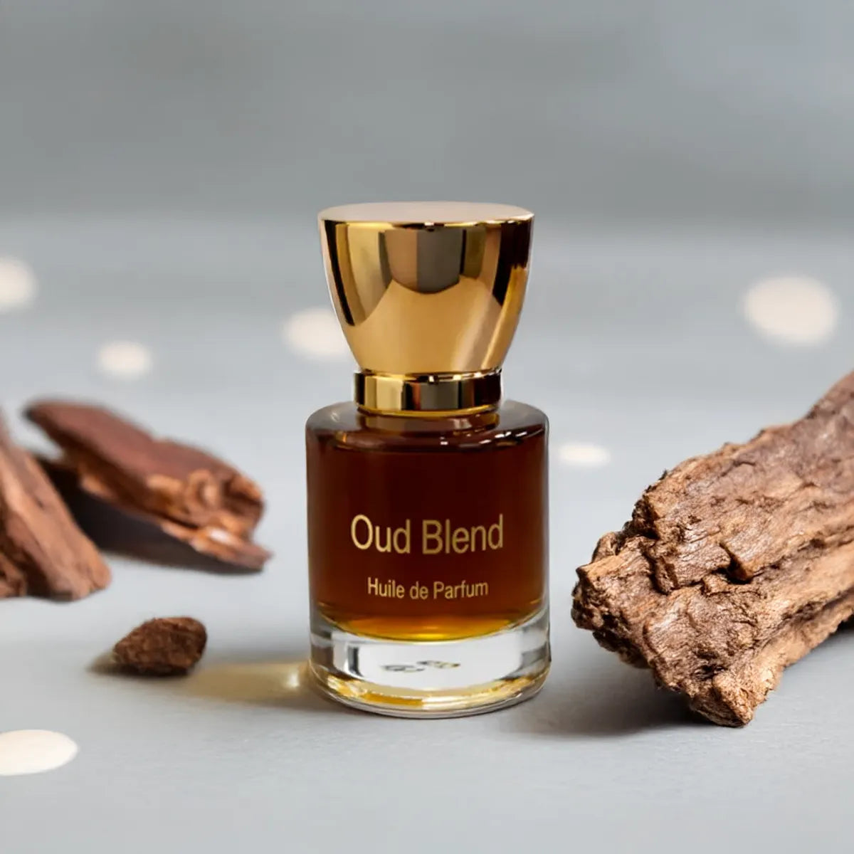 Oud Blend perfume bottle displayed with natural oud wood pieces on a soft neutral surface